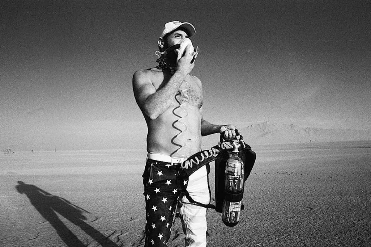 Capitalist Man — breathing from the tank, black and white desert