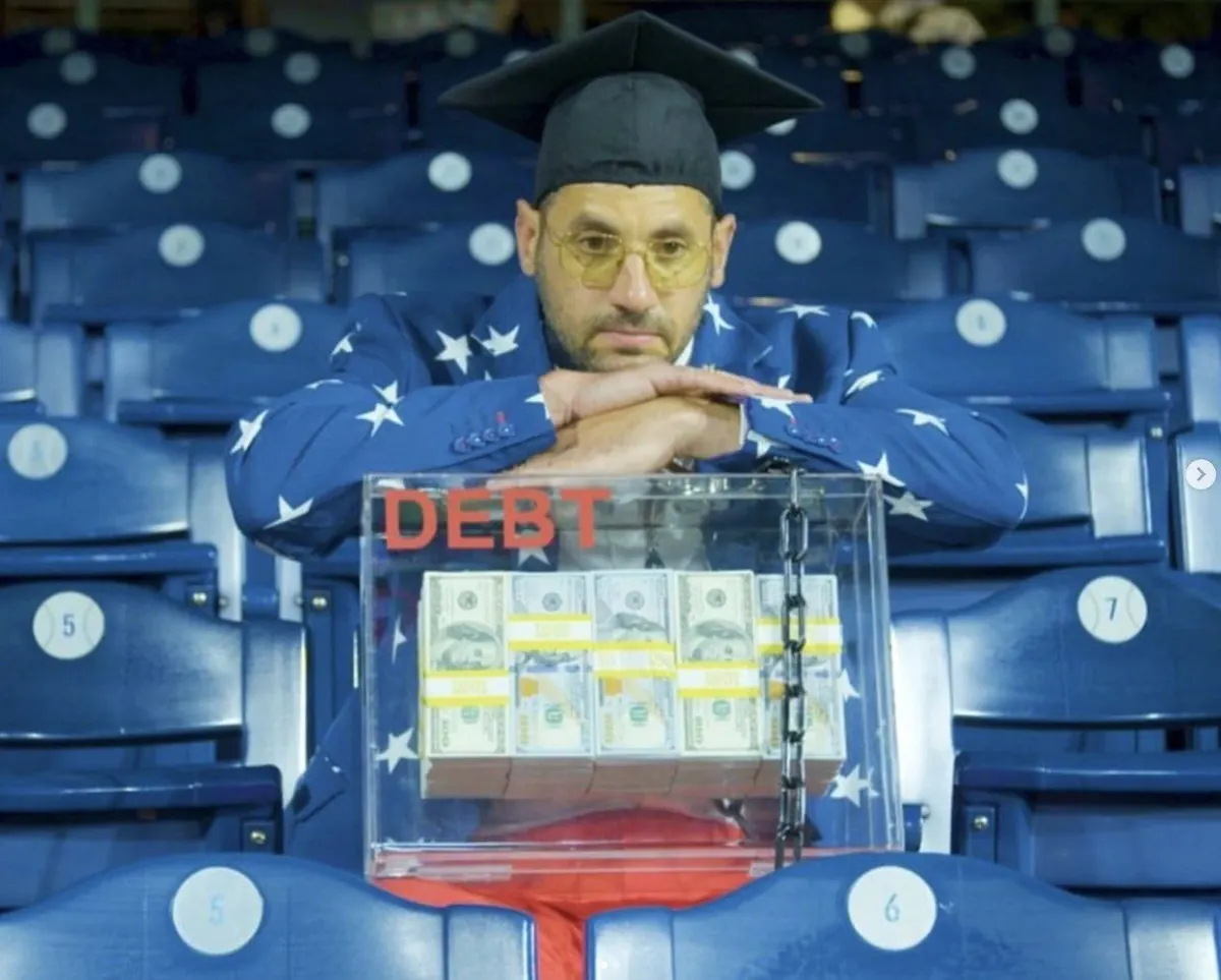 Capitalist Man — DEBT box in the stadium, graduation cap