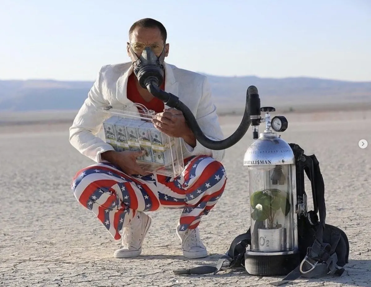 Capitalist Man — crouched with the O2 money tank in the desert